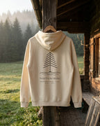 Rückseite Hoodie Höhenlage in Natural Raw mit Tannen-Motiv und Schriftzug Todtnauberg, an einer Almhütte vor nebligem Tannenwald
